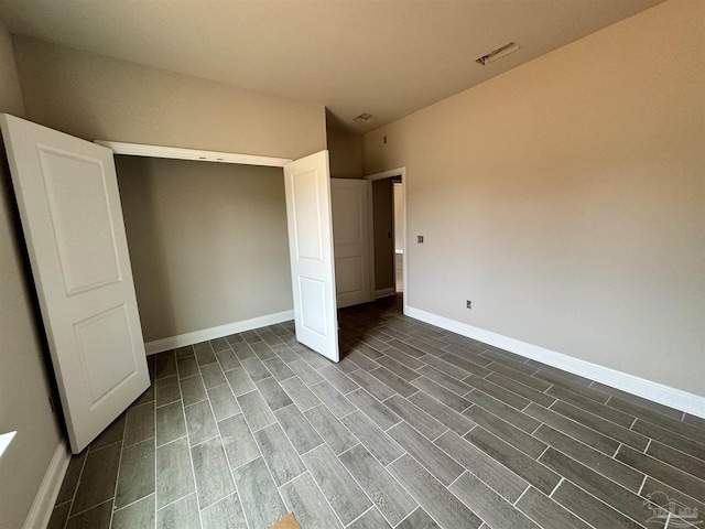 unfurnished bedroom with baseboards, visible vents, and wood finish floors