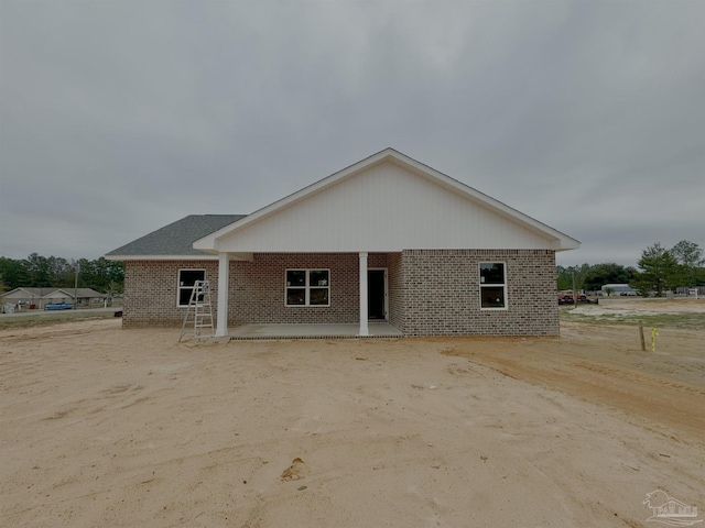 view of front of home with a patio area and brick siding