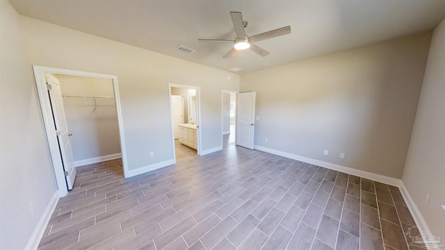 unfurnished bedroom featuring visible vents, a spacious closet, and baseboards