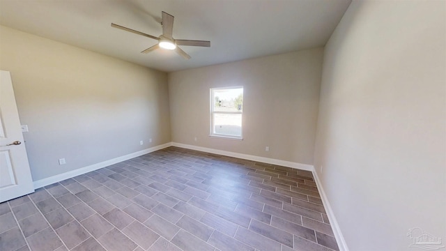 empty room with ceiling fan and baseboards