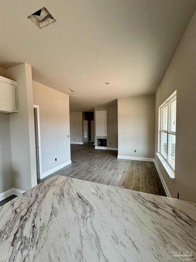 unfurnished living room with wood finish floors and baseboards