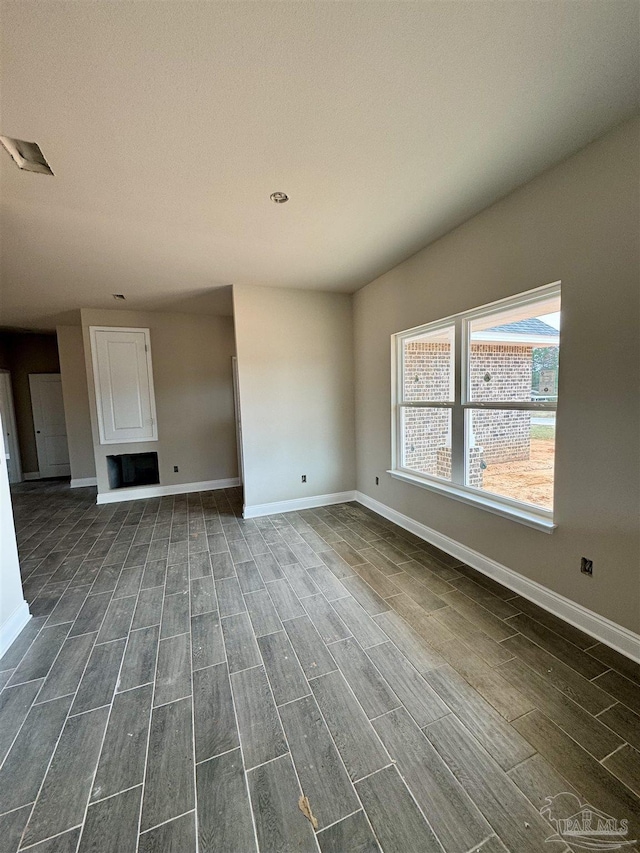 unfurnished living room with wood tiled floor and baseboards