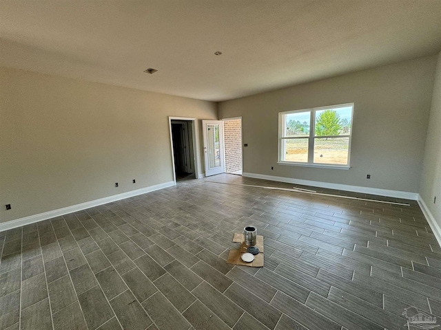 unfurnished room with baseboards and wood tiled floor