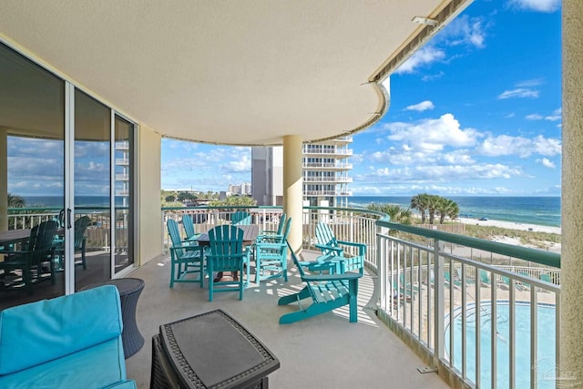 balcony featuring a water view and a view of the beach