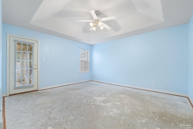 spare room featuring a raised ceiling, a textured ceiling, and ceiling fan