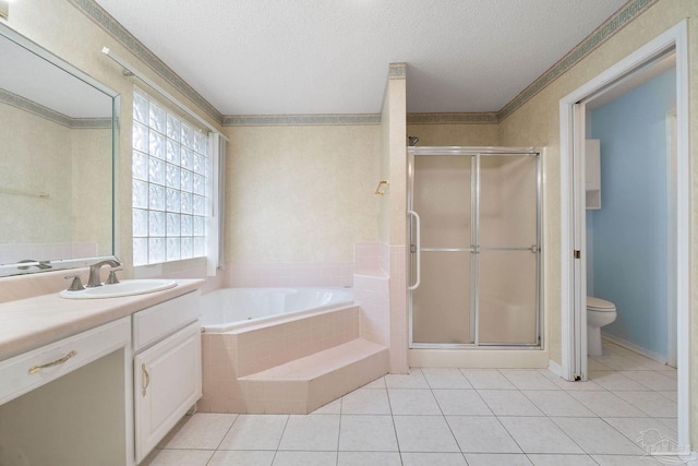 full bathroom featuring vanity, toilet, independent shower and bath, and a textured ceiling