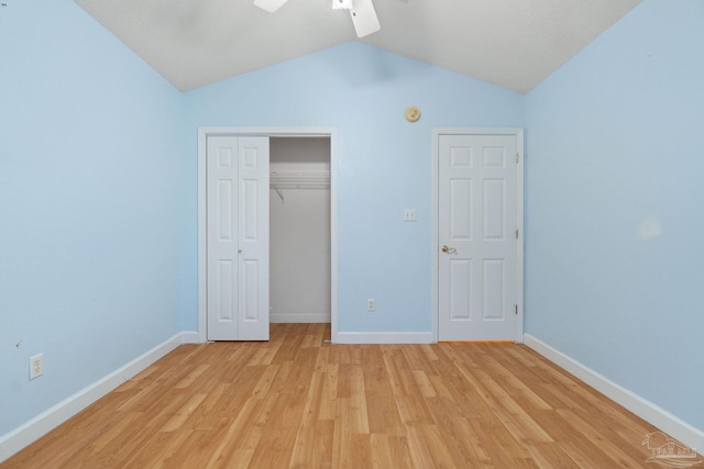 unfurnished bedroom with ceiling fan, lofted ceiling, a closet, and light wood-type flooring