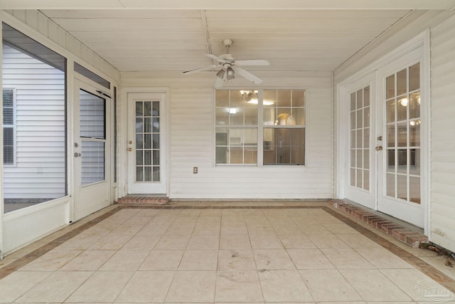 unfurnished sunroom featuring ceiling fan