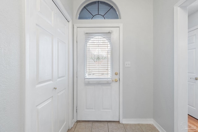 doorway to outside featuring light tile patterned flooring