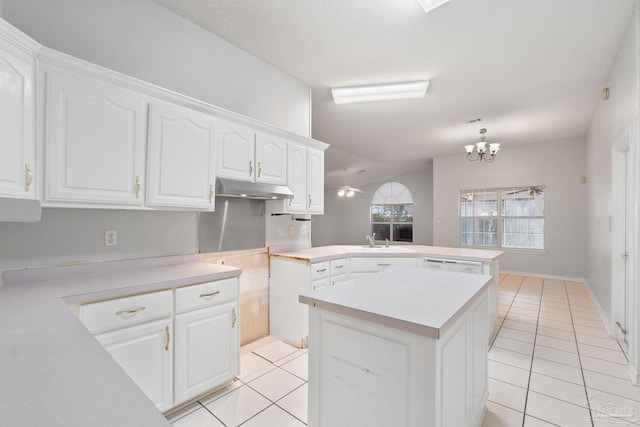 kitchen featuring light tile patterned floors, kitchen peninsula, white cabinets, and a center island