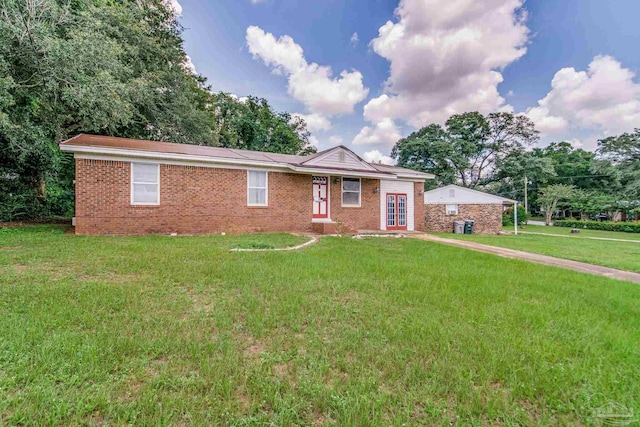 ranch-style home featuring brick siding and a front lawn