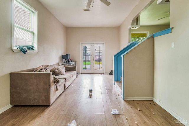 sitting room featuring light wood-style flooring, visible vents, baseboards, a ceiling fan, and french doors