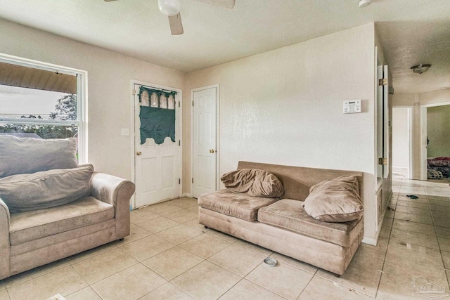 living area featuring light tile patterned floors and a ceiling fan