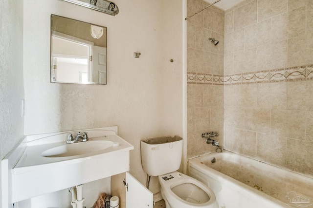 bathroom featuring shower / bathtub combination, a sink, and toilet