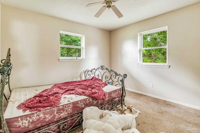 carpeted bedroom featuring ceiling fan and baseboards