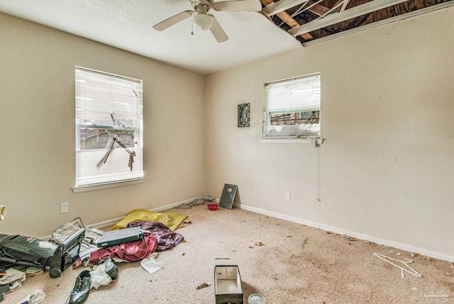 unfurnished room featuring a ceiling fan, carpet flooring, plenty of natural light, and baseboards