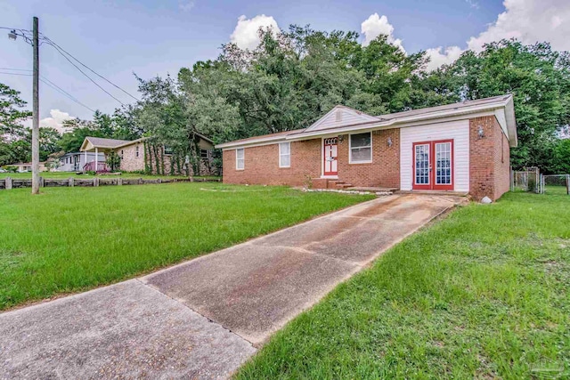 ranch-style home with a front lawn, french doors, and brick siding