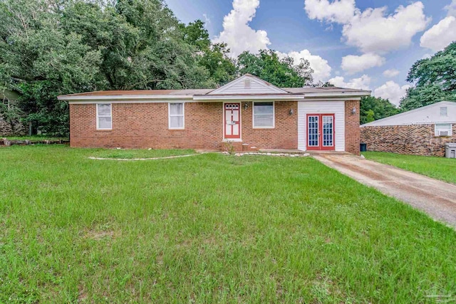 ranch-style home featuring french doors, brick siding, driveway, and a front lawn