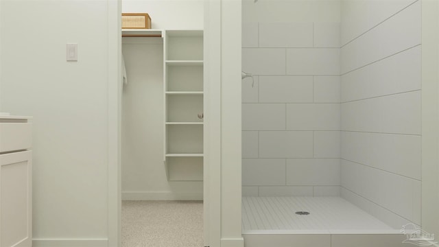 bathroom with vanity and a tile shower