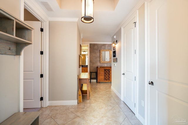 hall with ornamental molding and light tile patterned flooring