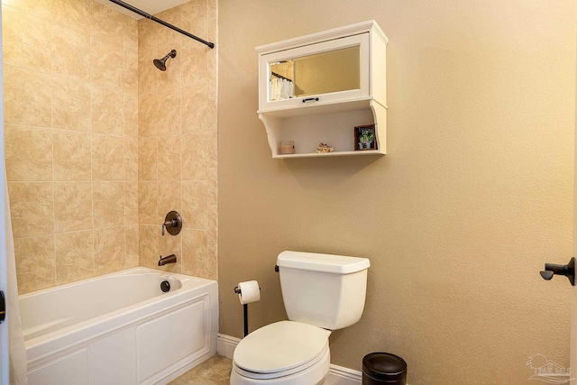 bathroom with toilet and tiled shower / bath combo