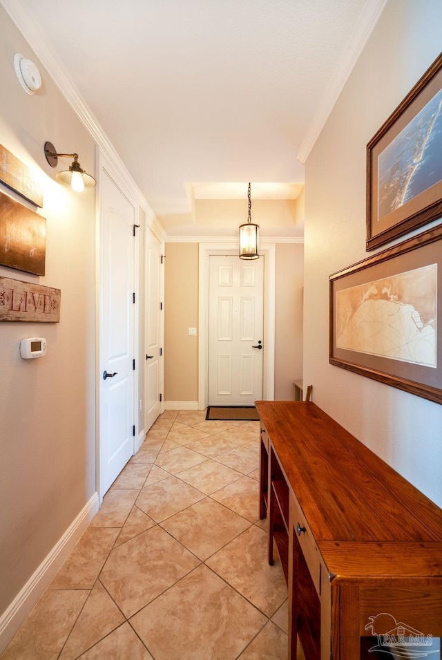 hall featuring light tile patterned floors and ornamental molding