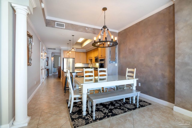 tiled dining area with a raised ceiling, ornate columns, and ornamental molding