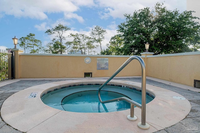 view of swimming pool featuring a hot tub