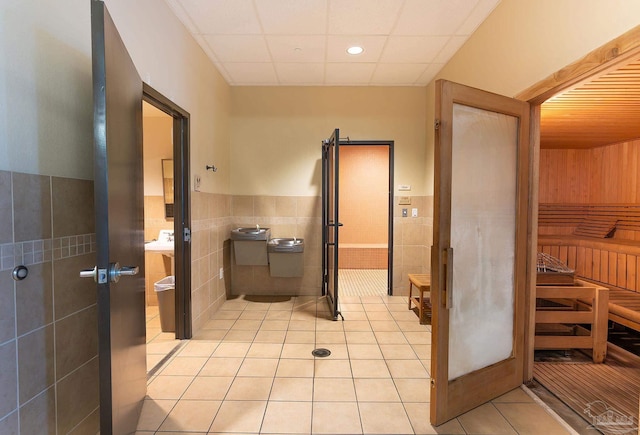 bathroom featuring tile walls, tile patterned flooring, and a paneled ceiling