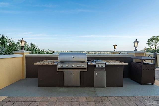 view of patio / terrace featuring exterior kitchen and a grill