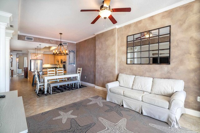 tiled living room featuring ornamental molding and ceiling fan with notable chandelier