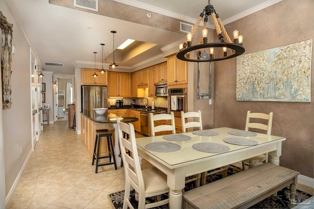 dining area with sink, crown molding, a notable chandelier, and light tile patterned flooring