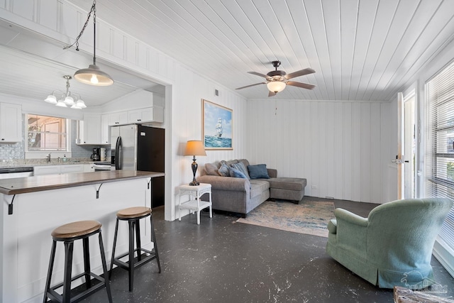 living area with visible vents, wooden ceiling, and ceiling fan with notable chandelier