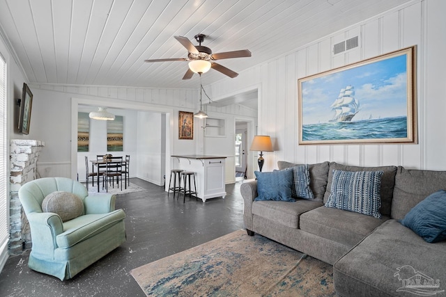 living area with a ceiling fan, visible vents, and wood ceiling