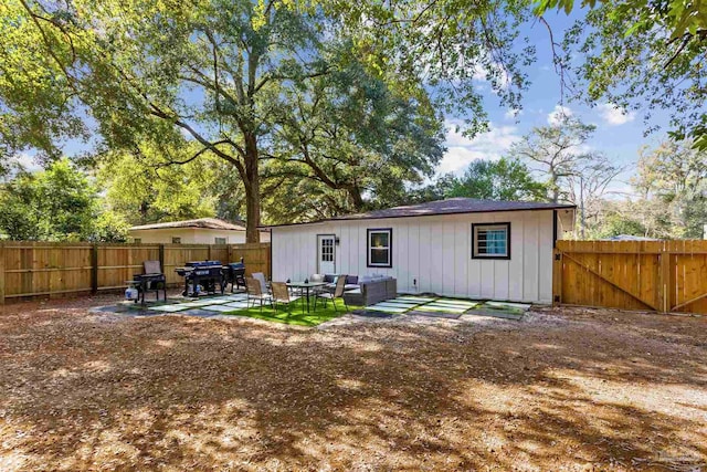 rear view of property with outdoor lounge area and a patio area