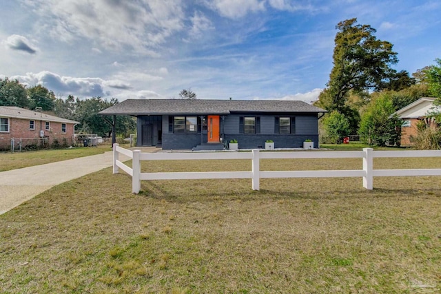 view of front facade with a front yard, fence, and driveway