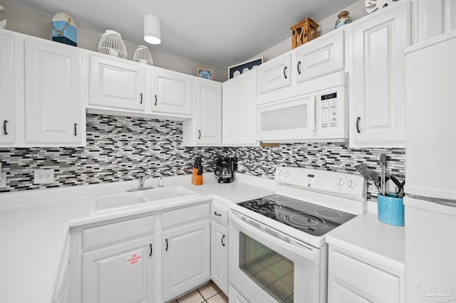 kitchen with tasteful backsplash, sink, white appliances, and white cabinets