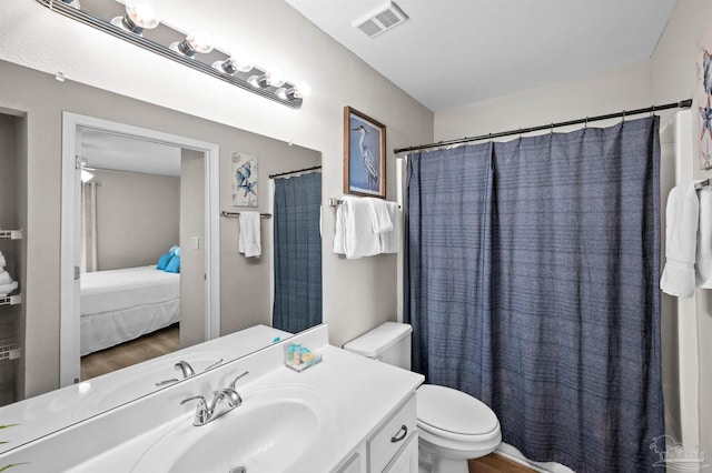 bathroom with vanity, toilet, and hardwood / wood-style floors