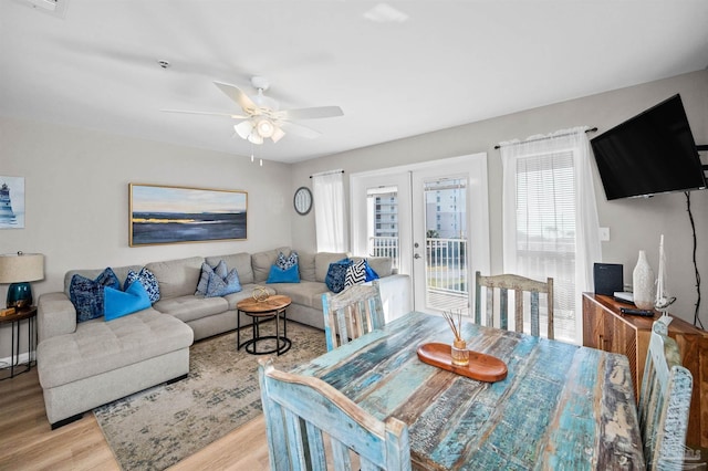 dining space with french doors, ceiling fan, and light wood-type flooring