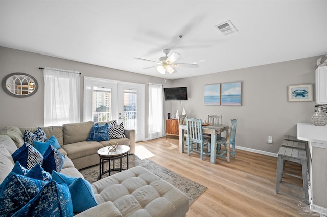 living room with ceiling fan, light hardwood / wood-style floors, and french doors