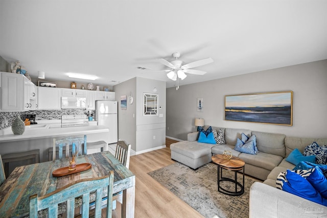 living room featuring ceiling fan and light wood-type flooring