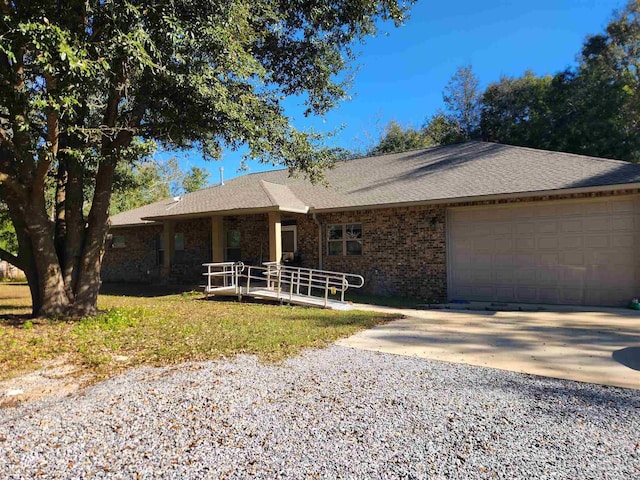 ranch-style home with a garage, brick siding, driveway, and a shingled roof