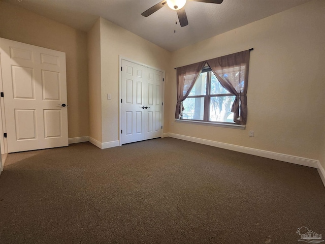 unfurnished bedroom featuring dark carpet, ceiling fan, and a closet