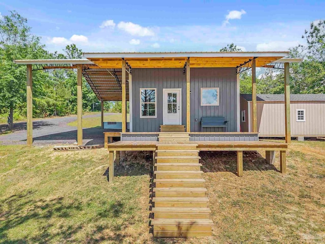 exterior space with a front lawn, an outdoor structure, and a carport