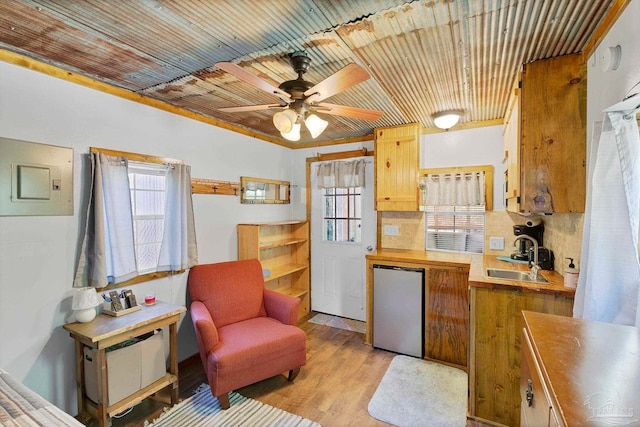 kitchen with stainless steel fridge, a sink, a healthy amount of sunlight, and wooden ceiling