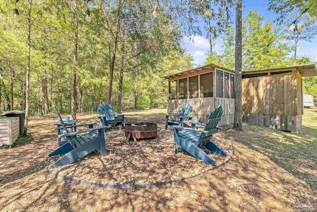 view of patio featuring a sunroom and a fire pit