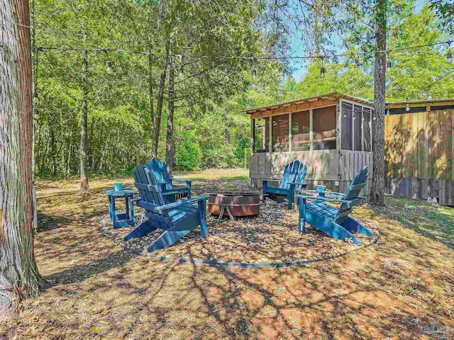 view of yard featuring a sunroom and an outdoor fire pit
