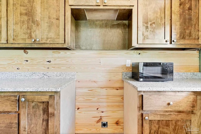 room details featuring black microwave and light stone counters