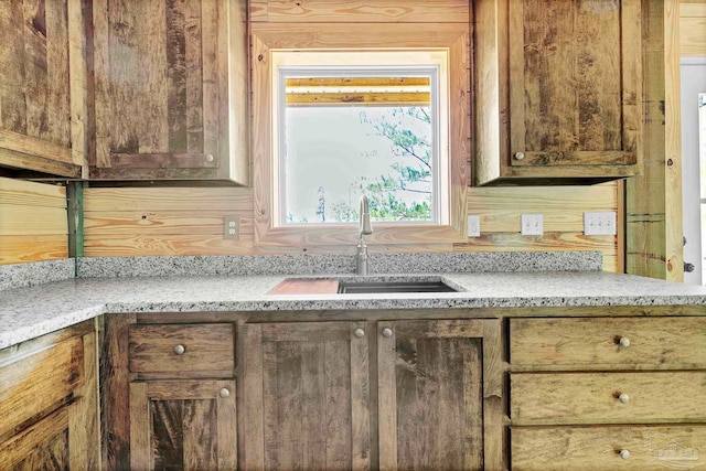 kitchen with a sink and light stone countertops