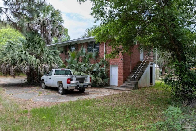 view of front of house with stairs and brick siding